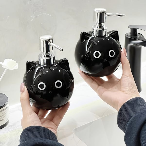 Keraamisessa lotion-pullossa on pyöreäsilmäinen musta kissa -design. black