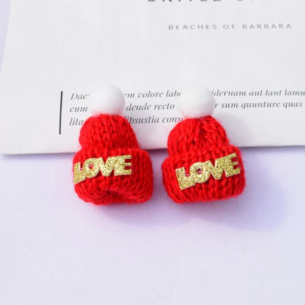 Liten stickad julhatt i ull med tofsar och ornament