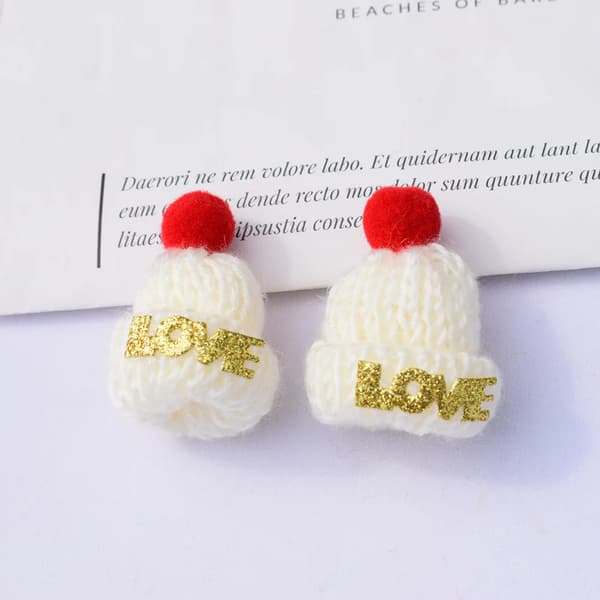 Liten stickad julhatt i ull med tofsar och ornament
