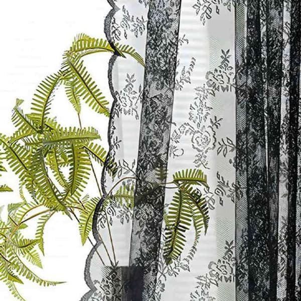 2 paneler svarta spetsgardiner, rustikt blommönster, texturerat polyestertyg, ljusfiltrerande, avskildhet för vardagsrum och sovrum.