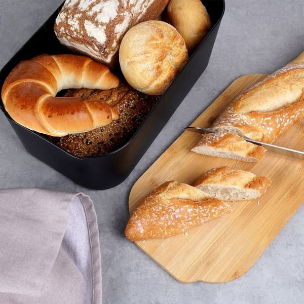 Musta leipälaatikko bambuisella leikkuulaudalla