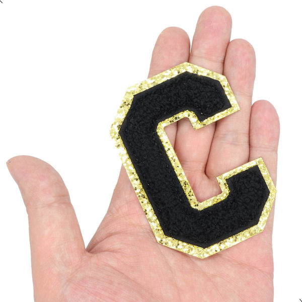 Englannin kirjaimen C rauta-sovellettavat korjauslaastarit Aakkosten ompelutarrat Vaatteiden merkit, kultaisen glitterin reunalla, liimapintainen tarra (Musta C) CBlack