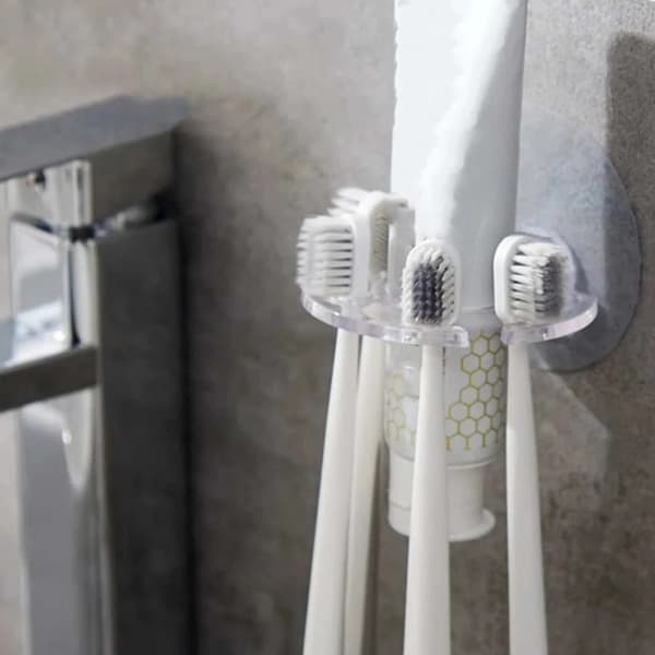 Wall-mounted toothbrush holder with suction cups and toothpaste storage, suitable for the bathroom.