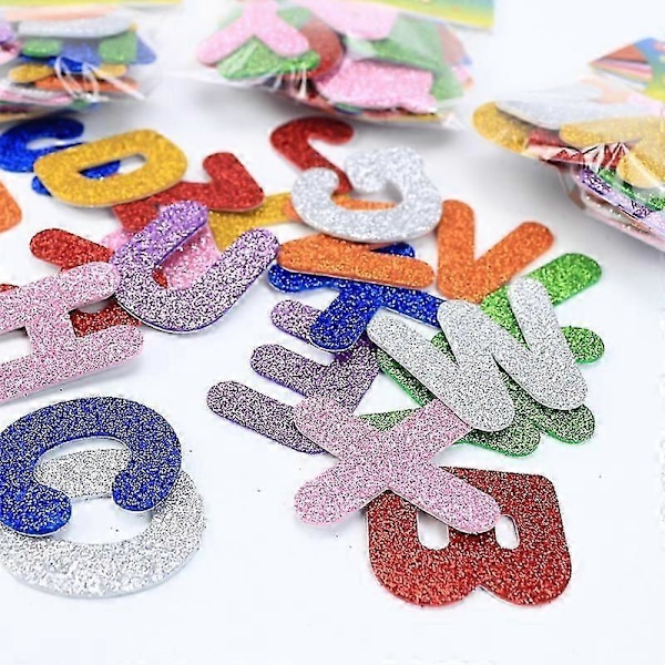 2 pakkausta pieniä aakkoskirjainvaahtomuovitarroja glitterillä, askartelutarvikkeita