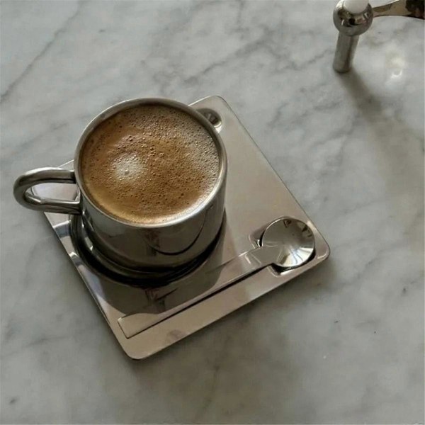 Kaffekoppset med sked, bordstablett, vattenkopp, bordsartiklar, som visat