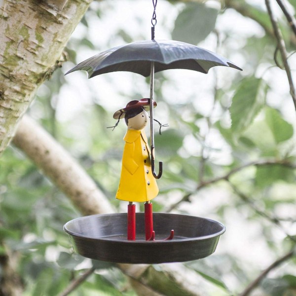 Girl's Metal Bird Mater i hagen med hengende kjede og gammeldags metallparaply for ville fugler
