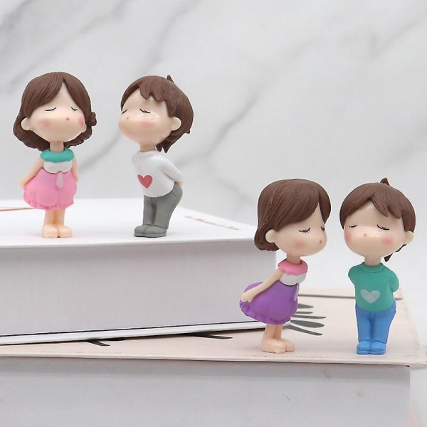 4 lapsen set, joka suutelee pariskuntanukkelelumalleja pöytäkakkujen koristeluun