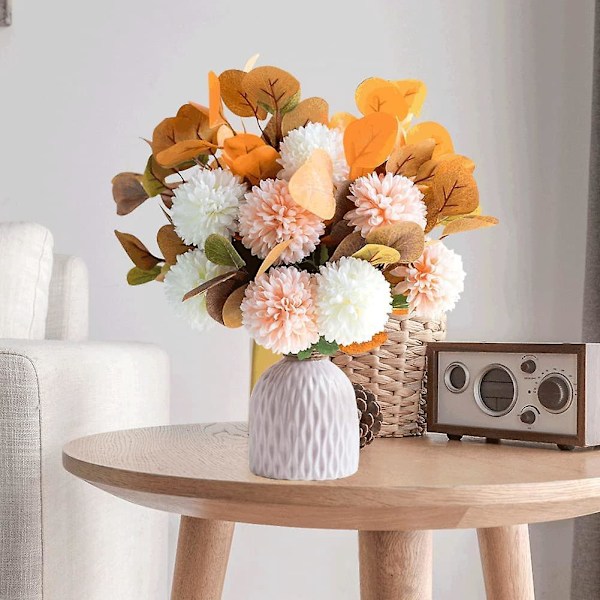 Kunstig broderi med keramisk vase - imitasjon av en bukett broderte blomster dekorerer familiens samlingsbord med en ekte oransje blomst