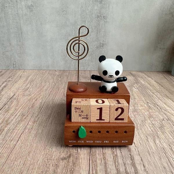 Puinen musiikkilaatikko pöytäkalenteri panda-patsaalla makuuhuoneen kaapin työpöydälle