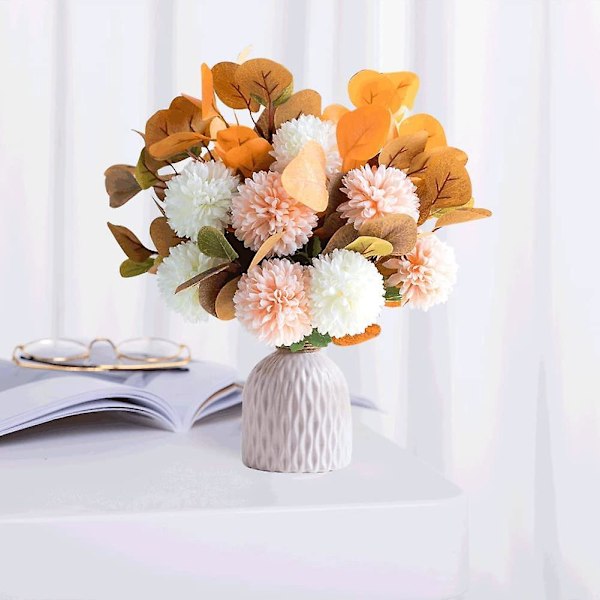 Kunstig broderi med keramisk vase - imitasjon av en bukett broderte blomster dekorerer familiens samlingsbord med en ekte oransje blomst